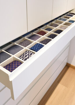 White tie drawer with various rolled ties aligned