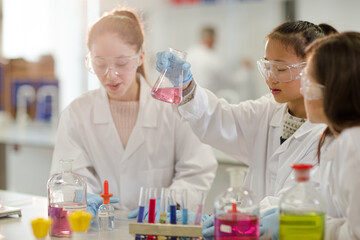 Girl students conducting scientific experiment in laboratory classroom