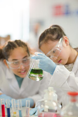 Students watching chemical reaction, conducting scientific experiment in laboratory classroom