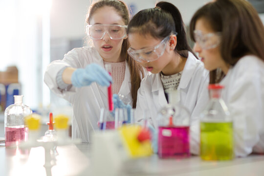 Girl students conducting scientific experiment in laboratory classroom