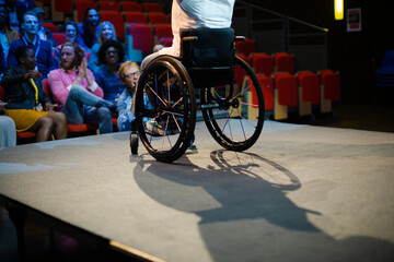 Obraz na płótnie Canvas Audience watching speaker in wheelchair talking on stage
