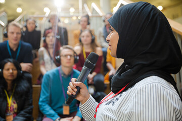 Fototapeta na wymiar Female speaker in hijab talking to audience