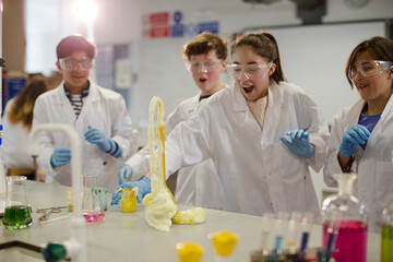 Surprised students conducting exploding foam scientific experiment in classroom laboratory