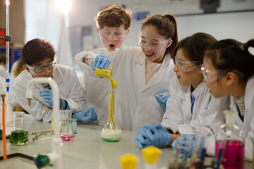 Surprised students conducting exploding foam scientific experiment in classroom laboratory