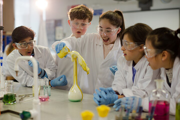 Surprised students conducting exploding foam scientific experiment in classroom laboratory