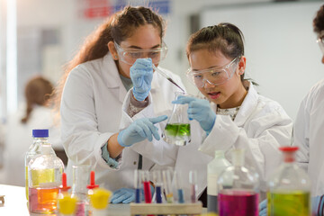 Students watching chemical reaction, conducting scientific experiment in laboratory classroom