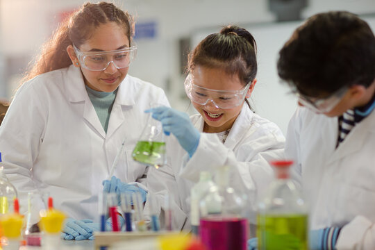 Students watching chemical reaction, conducting scientific experiment in laboratory classroom