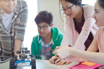 Students playing with robot in classroom