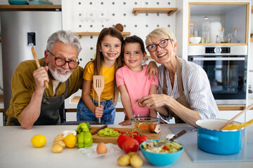 Cheerful family spending good time together while cooking in kitchen