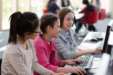 Girl students using computer in library