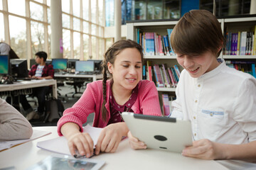 Students using digital tablet in library