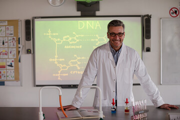 Portrait male science teacher teaching DNA lesson at projection screen