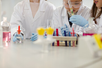 Fototapeta premium Girl students conducting scientific experiment in laboratory classroom