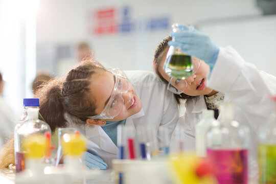 Students watching chemical reaction, conducting scientific experiment in laboratory classroom
