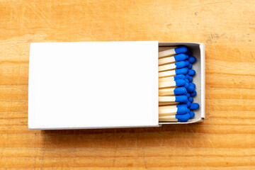 Cardboard box with matchsticks on wooden background, blank space top view. Space for design,flat...