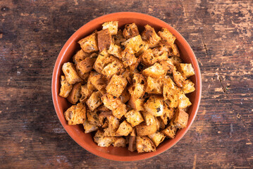 Homemade ciabatta croutons in a bowl on the table, top view