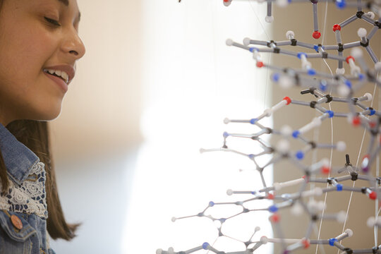 Curious girl student examining molecular structure