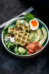 Belgian waffles with salmon, avocado and egg in a plate