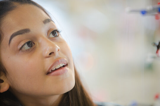 Curious girl student examining molecular structure