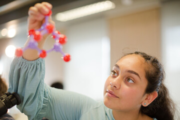 Obraz na płótnie Canvas Curious girl student examining molecular structure