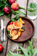 Sweet cheesecakes with peach in a plate close-up. Breakfast