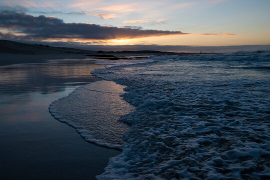 Waves breaking along the coastline at dawn