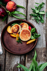 Sweet cheesecakes with peach in a plate close-up. Breakfast
