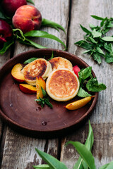 Sweet cheesecakes with peach in a plate close-up. Breakfast