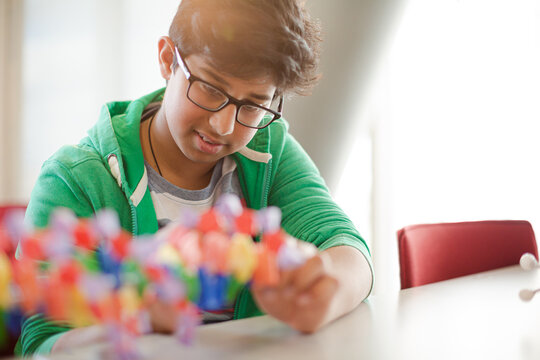 Boy student examining DNA model in classroom