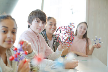 Portrait confident students holding molecular structures in laboratory classroom