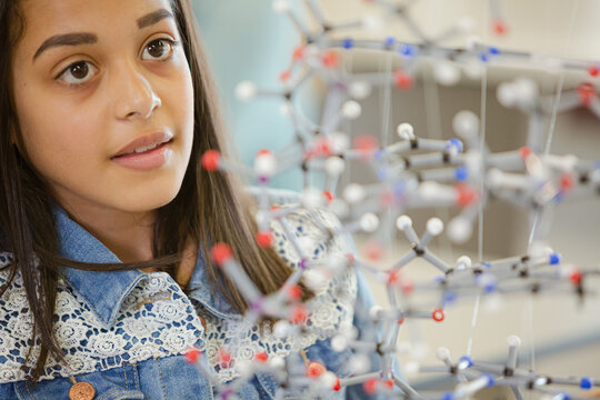 Portrait smiling girl student holding molecular model in laboratory classroom