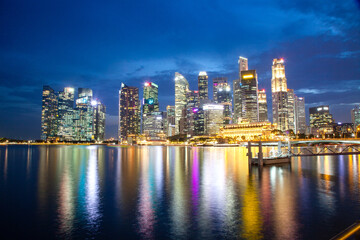 Fototapeta na wymiar SINGAPORE, SINGAPORE - MARCH 2019: Skyline of Singapore Marina Bay at night with Marina Bay sands, Art Science museum , skyscrapers and tourist boats