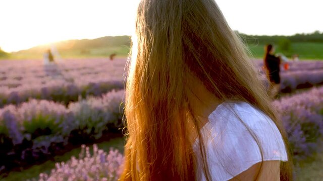 a girl with long hair runs in a lavender field