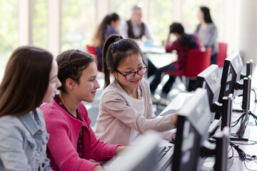 Fototapeta premium Girl students using computer in library