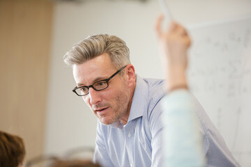 Fototapeta premium Male teacher leading lesson at whiteboard in classroom