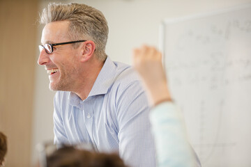 Fototapeta premium Male teacher leading lesson at whiteboard in classroom