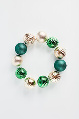 beautiful wreath of Christmas decorations in the form of balls of gold and turquoise on a white background. minimalistic festive composition. flat layout with copy space