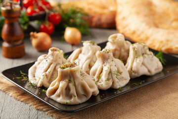 Traditional Georgian dumplings with meat. Khinkali. Served on a plate with traditional Georgian bread.