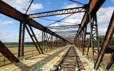 Old railway line crossing a rusty bridge turned into recreational track for rail-cycle draisine...