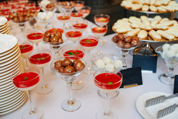 glasses of smoothies decorated with mint leaf, eclair cakes and chocolates. 