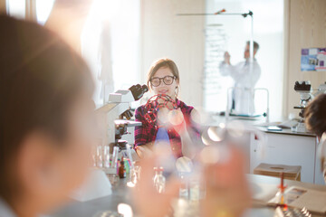 Curious girl student examining molecular structure in classroom