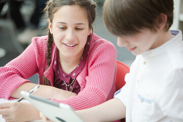 Students using digital tablet in library