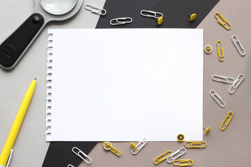 Top view of notepad sheet mockup with copy space. surrounded by stationery on a three-color black, gray, brown background. Education and office concept