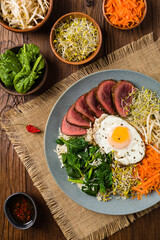 Korean beef with sprouts, spinach and fried egg.