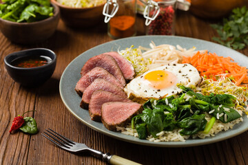 Korean beef with sprouts, spinach and fried egg.