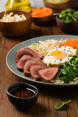 Korean beef with sprouts, spinach and fried egg.