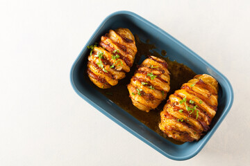 Baked potatoes in Swedish. Hasselback. Stuffed with cheese and bacon. Top view.