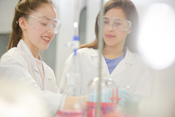 Girl students conducting science experiment in classroom laboratory