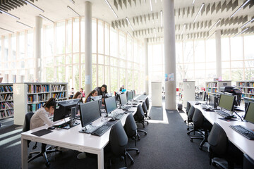 Fototapeta na wymiar Students working on computers in library