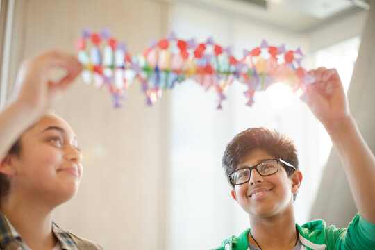 Students examining DNA model in classroom laboratory
